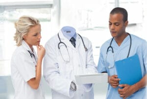 A group of doctors looking at a tablet.