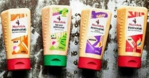 Four tubes of nadodo's ketchup on a wooden surface.